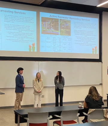 students standing in front of the classroom presenting a powerpoint