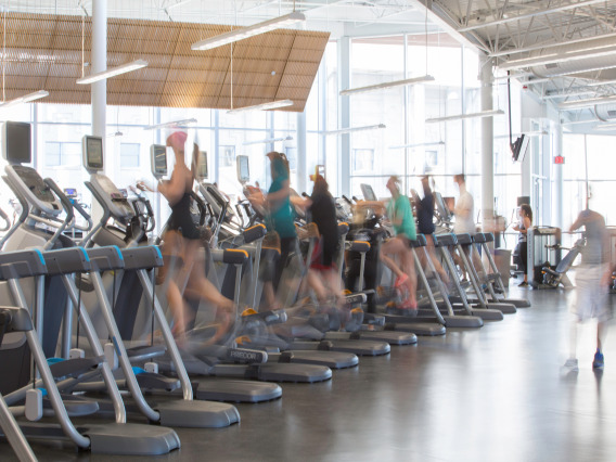 People running on gym equipment at the University of Arizona Recreational Center.