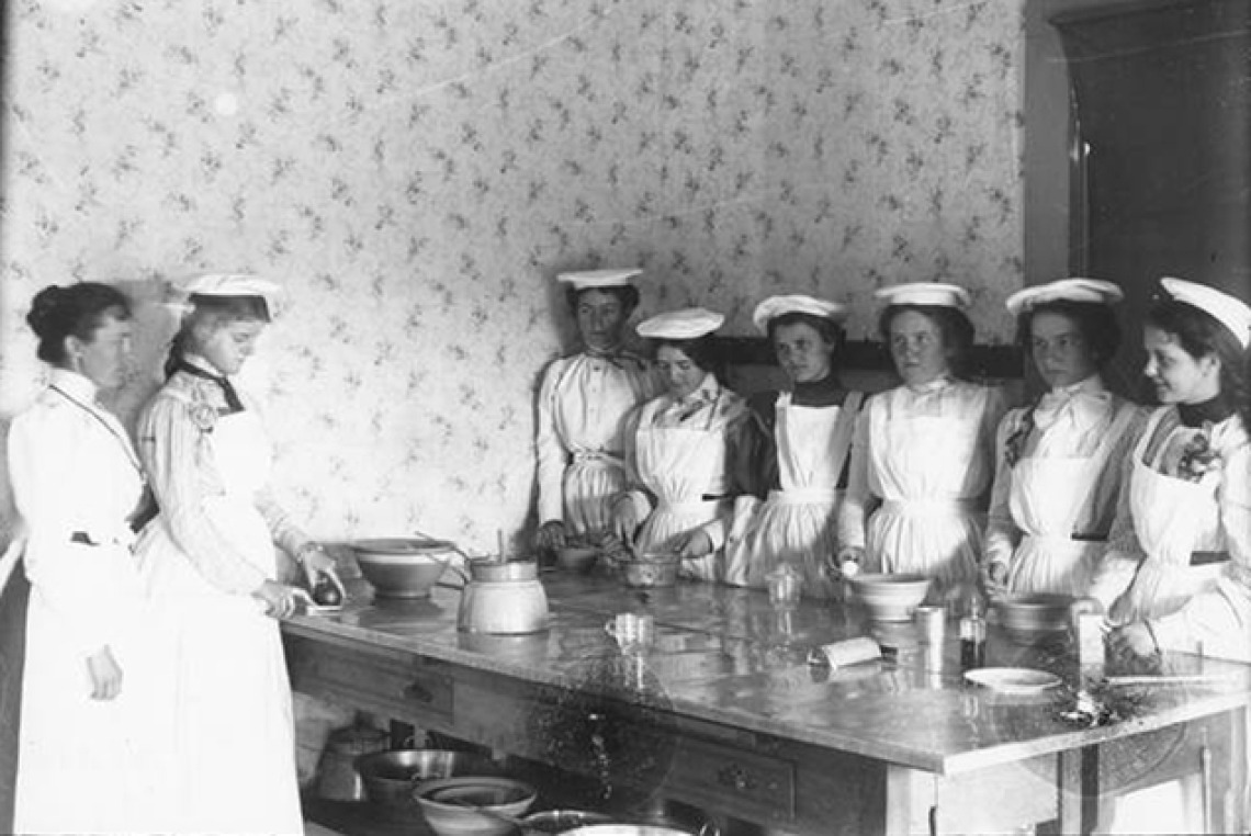 black and white image of students in  the early 20th century in domestic science lab