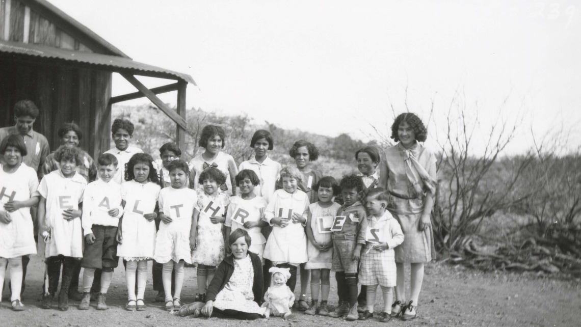 A CES agent with children in rural Arizona circa 1920